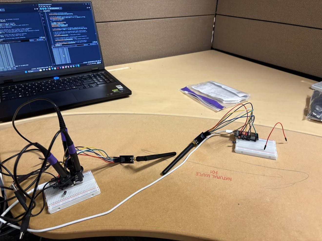 The ESP32 and nRF24L01 radios on breadboards, with scope probes on the SPI lines and firmware open on the laptop.